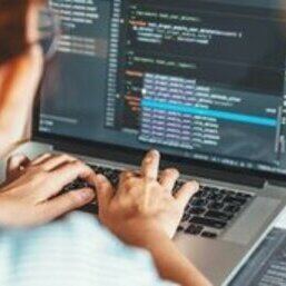 Developer writing code on a laptop